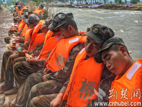 連續奮戰25小時 抗洪官兵拿著面包睡著了